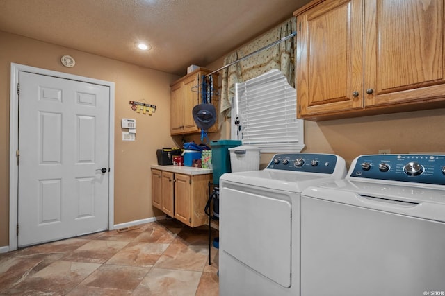 clothes washing area featuring cabinet space, baseboards, and washer and clothes dryer