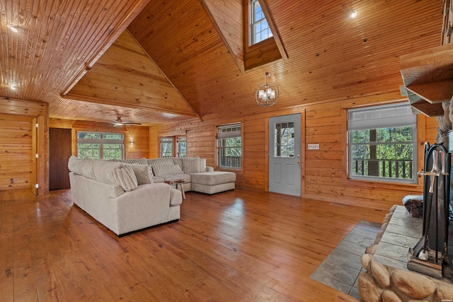 living area with high vaulted ceiling, wood ceiling, wood walls, and wood finished floors