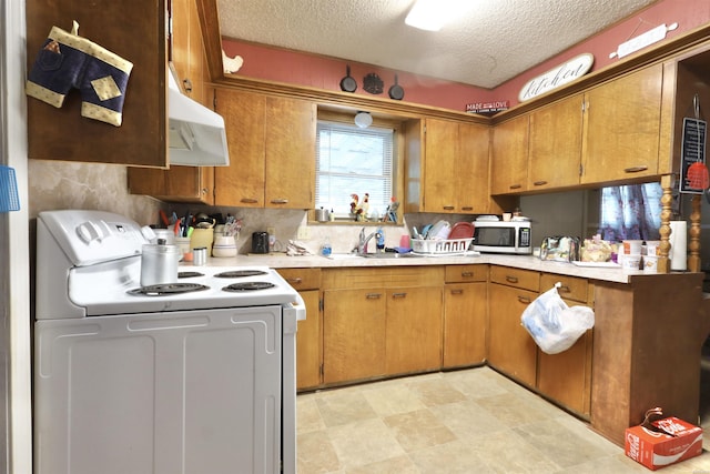 kitchen featuring light countertops, stainless steel microwave, a sink, and white electric range oven