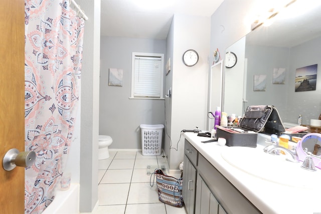 bathroom featuring tile patterned flooring, toilet, vanity, baseboards, and shower / bath combo with shower curtain