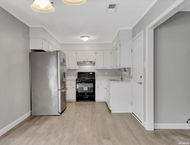 kitchen with freestanding refrigerator, light countertops, black gas stove, under cabinet range hood, and white cabinetry