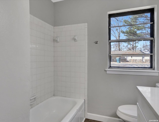 bathroom with toilet, shower / tub combination, baseboards, and vanity