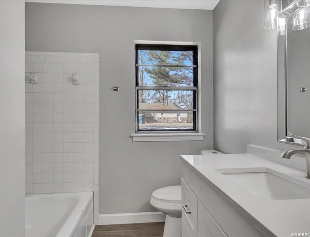 full bath featuring bathing tub / shower combination, toilet, vanity, wood finished floors, and baseboards