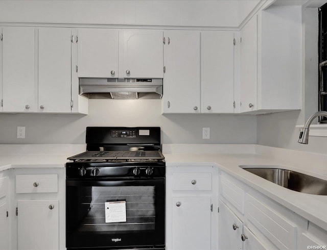 kitchen featuring under cabinet range hood, a sink, white cabinetry, light countertops, and black gas range oven