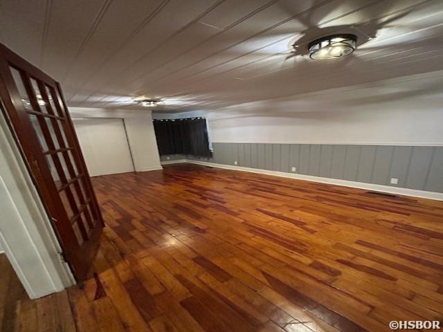 empty room featuring a wainscoted wall and wood finished floors