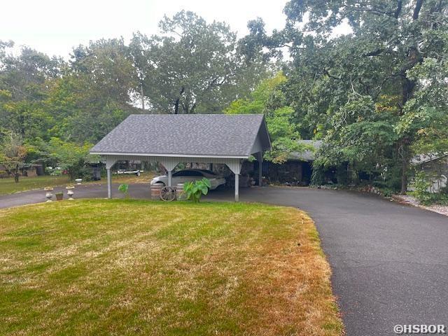 view of home's community featuring aphalt driveway and a lawn