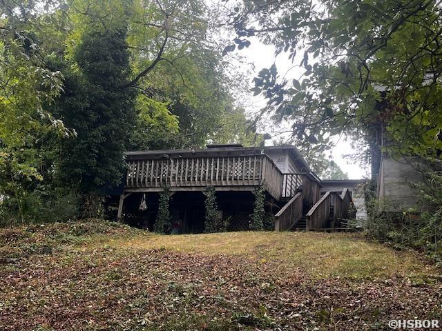 rear view of house featuring a wooden deck and stairs