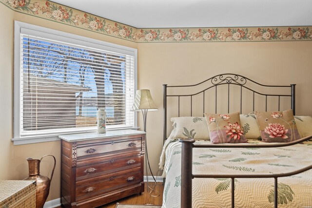 bedroom with baseboards and wood finished floors