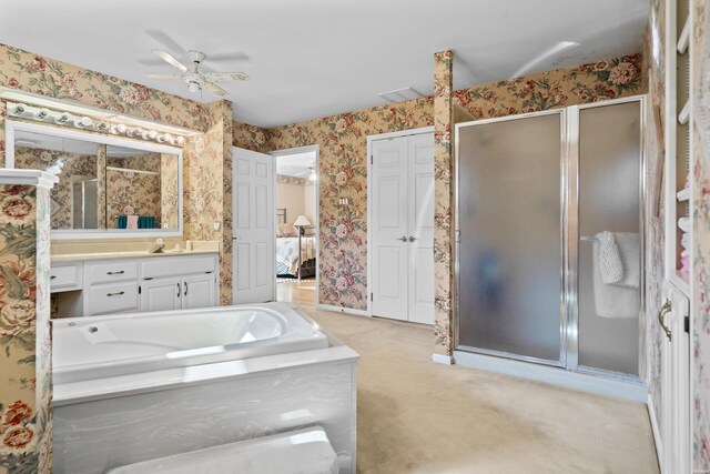 ensuite bathroom featuring a garden tub, a ceiling fan, a shower stall, vanity, and wallpapered walls