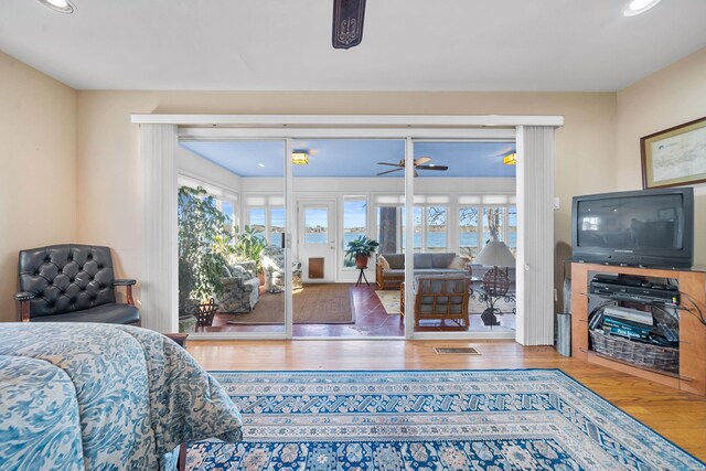 bedroom featuring access to outside, multiple windows, visible vents, and wood finished floors