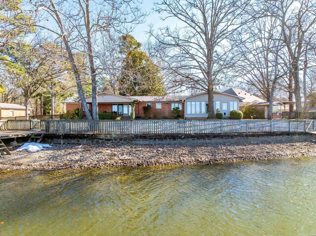 rear view of property with a water view and brick siding