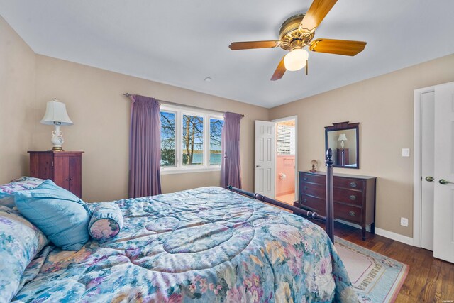 bedroom with connected bathroom, dark wood finished floors, a ceiling fan, and baseboards