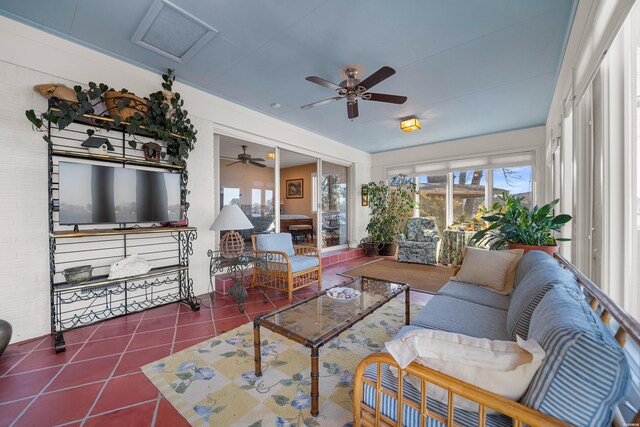 living room with dark tile patterned floors and a sunroom