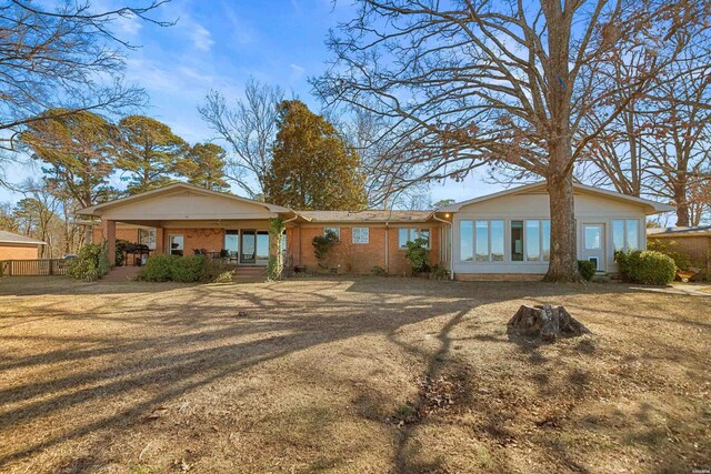 single story home with a porch, a front yard, and brick siding