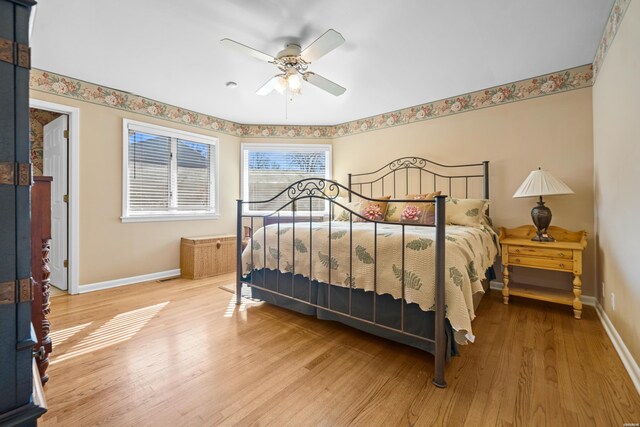 bedroom featuring ceiling fan, wood finished floors, and baseboards