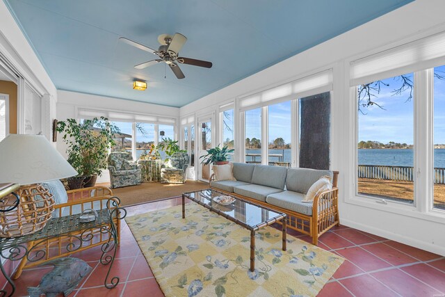 sunroom / solarium featuring a water view and a ceiling fan