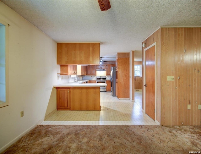 427 Morrison Rd, Arkadelphia, AR 71923 - kitchen with stainless steel appliances, a peninsula, brown cabinets, wood walls, and under cabinet range hood