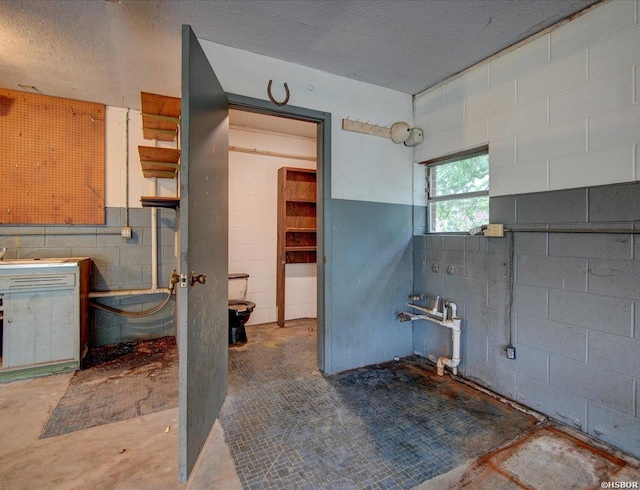 427 Morrison Rd, Arkadelphia, AR 71923 - bathroom featuring concrete block wall, a textured ceiling, and concrete floors