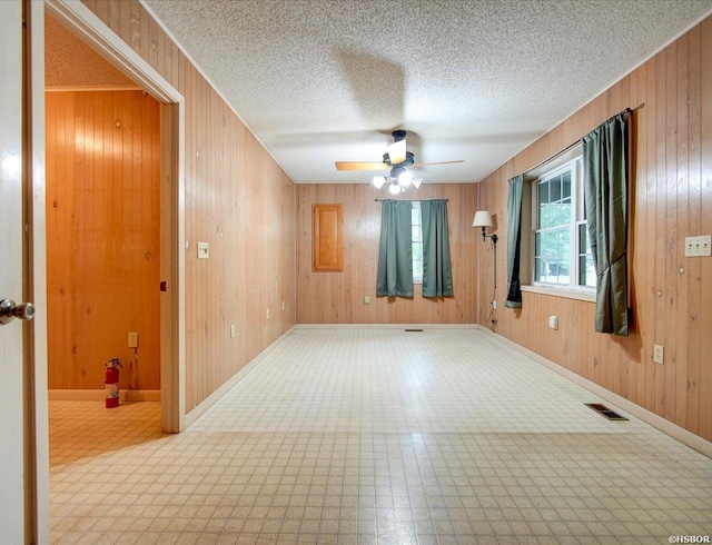 427 Morrison Rd, Arkadelphia, AR 71923 - empty room featuring ceiling fan, wooden walls, tile patterned floors, and a textured ceiling