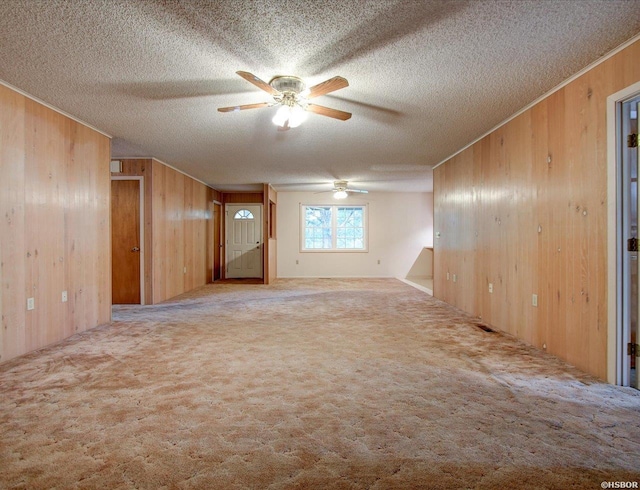 427 Morrison Rd, Arkadelphia, AR 71923 - empty room featuring wooden walls, a ceiling fan, a textured ceiling, carpet, and ornamental molding