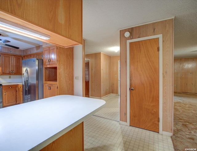 427 Morrison Rd, Arkadelphia, AR 71923 - kitchen with stainless steel fridge with ice dispenser, a textured ceiling, light countertops, wooden walls, and light flooring