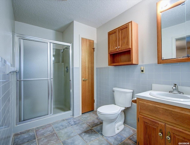 427 Morrison Rd, Arkadelphia, AR 71923 - bathroom with vanity, a stall shower, a textured ceiling, tile walls, and wainscoting