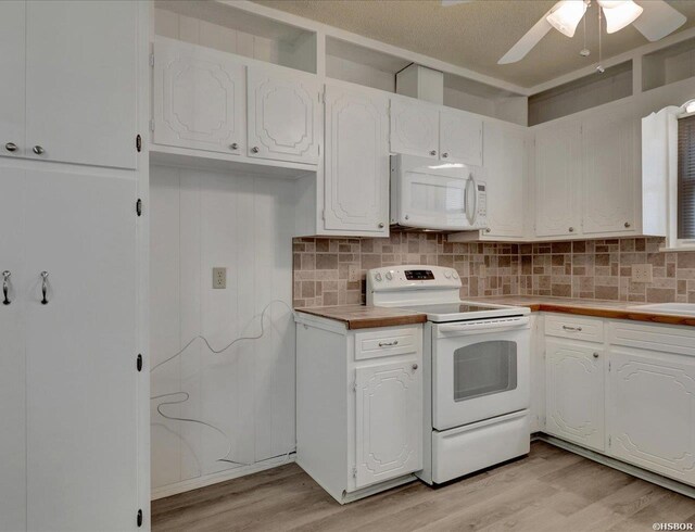 kitchen with white appliances, light wood-style floors, white cabinets, light countertops, and tasteful backsplash