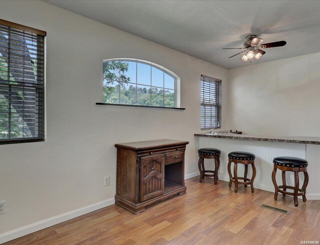 interior space with visible vents, ceiling fan, light wood-style flooring, and baseboards