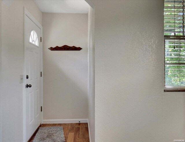 doorway to outside with wood finished floors and baseboards