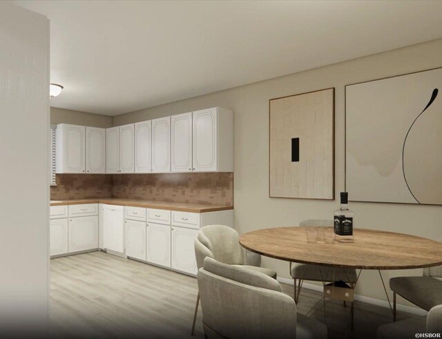 kitchen featuring tasteful backsplash, light wood-type flooring, white cabinetry, and baseboards