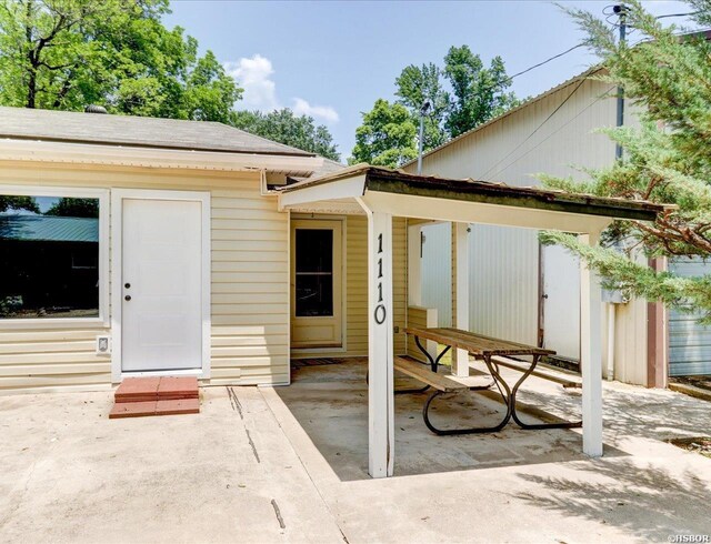 view of exterior entry with a patio