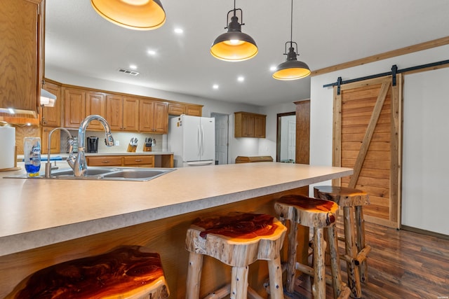 539 Charlie Stover Rd, Royal, AR 71968 - kitchen with a peninsula, a barn door, a breakfast bar, dark wood-type flooring, and freestanding refrigerator