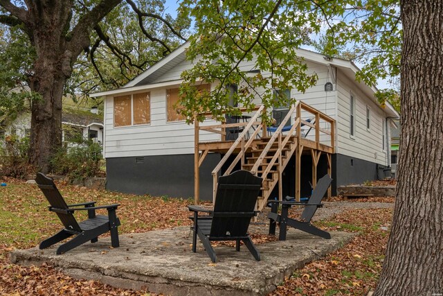 back of property with crawl space, a deck, and stairs