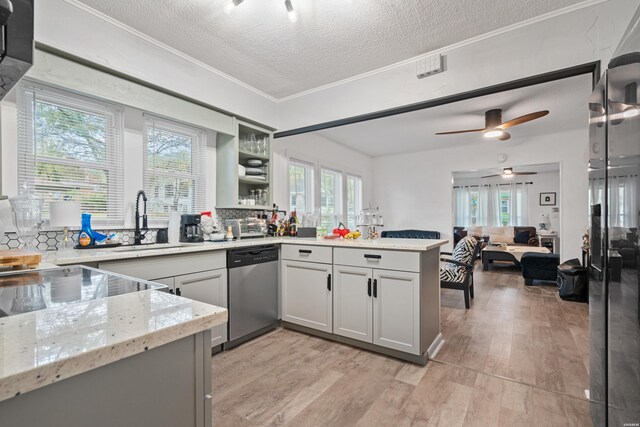 kitchen with gray cabinetry, stainless steel dishwasher, a sink, light stone countertops, and a peninsula