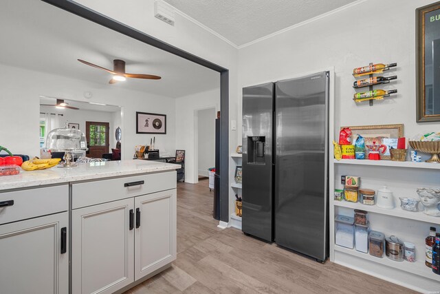 kitchen featuring a textured ceiling, light wood-style flooring, stainless steel fridge with ice dispenser, light stone countertops, and crown molding