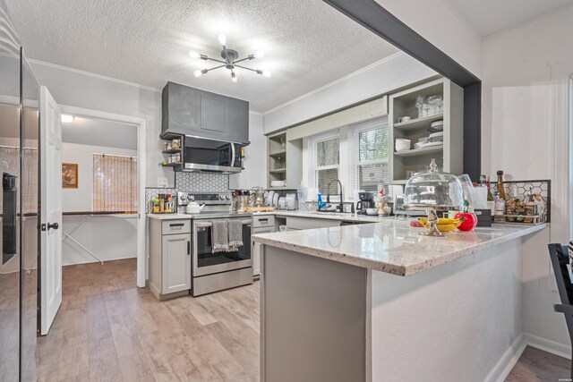 kitchen featuring a peninsula, appliances with stainless steel finishes, gray cabinets, light stone countertops, and open shelves