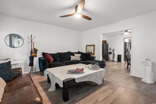 living room featuring a ceiling fan, light wood-style flooring, and baseboards