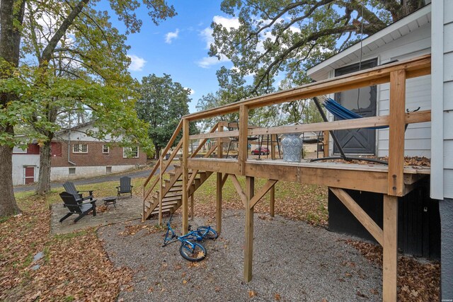 view of jungle gym featuring stairs, a fire pit, and a deck