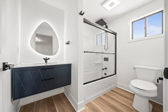 full bath featuring vanity, wood finished floors, toilet, and baseboards