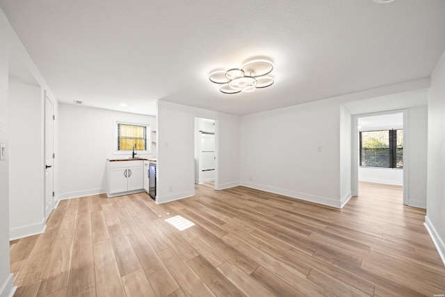 interior space with a sink, light wood-style flooring, and baseboards