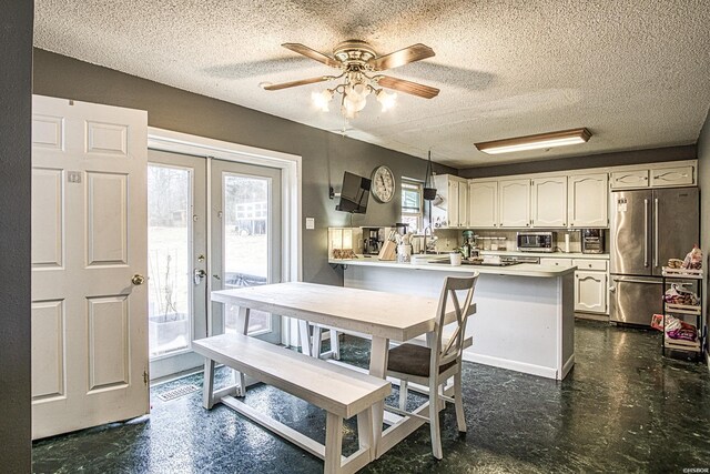 dining room with a wealth of natural light, french doors, ceiling fan, and a textured ceiling