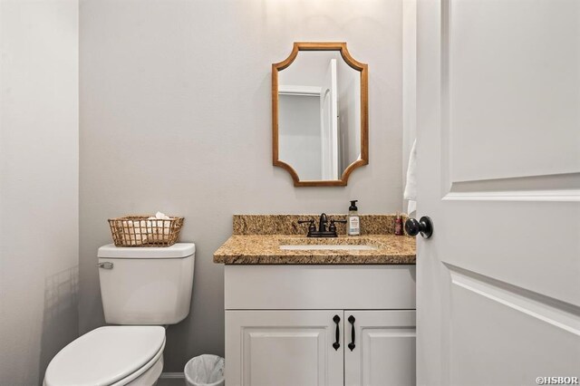 half bathroom with toilet and vanity