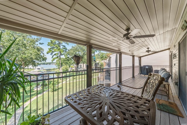 wooden deck with a grill, ceiling fan, and a lawn