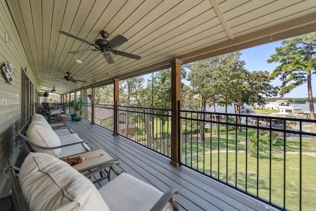 wooden terrace featuring ceiling fan, a lawn, and an outdoor hangout area