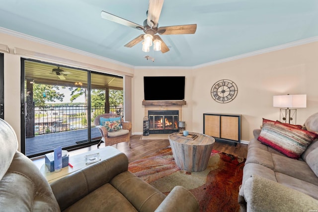 living area with a fireplace with flush hearth, ornamental molding, and wood finished floors