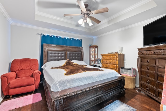 bedroom with dark wood-type flooring, a raised ceiling, visible vents, and crown molding