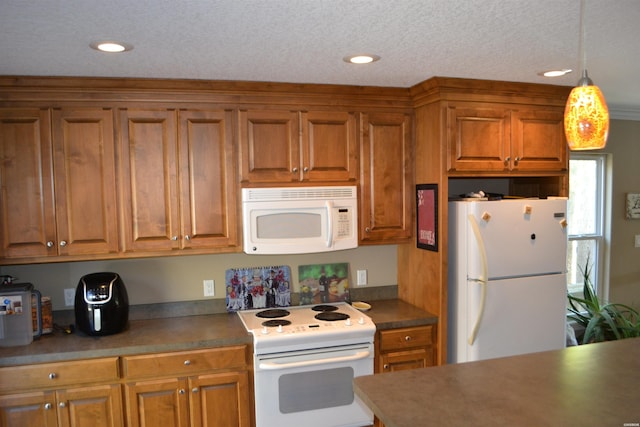 kitchen with dark countertops, white appliances, and brown cabinets