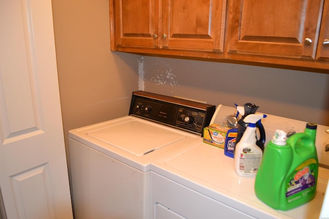 laundry room featuring independent washer and dryer and cabinet space