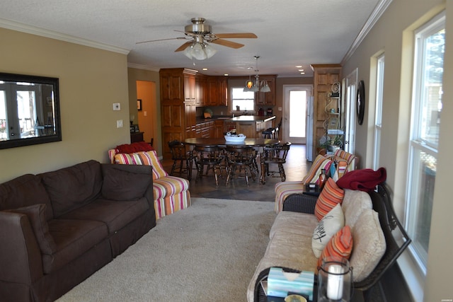 living area with crown molding, a textured ceiling, and ceiling fan