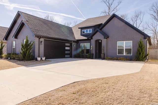 view of front facade featuring a garage, driveway, and brick siding